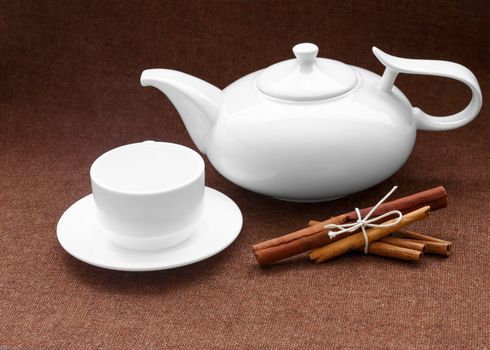 teapot, cup and cinnamon on sacking