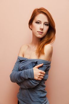Beautiful redhead girl near wall.