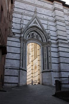 The sunlight lit entrance to the square that houses the Duomo of Siena.  