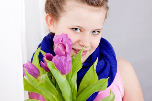 smiling teenager girl with pink tulips bouquet 
