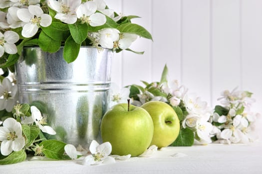 Green apples with blossoms on table