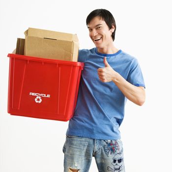 Portrait of smiling Asian young man standing holding recycling bin.