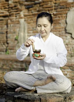 Woman playing a tibetan bowl, traditionally used to aid meditati