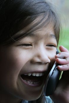 Six year old girl talking on cell phone.;