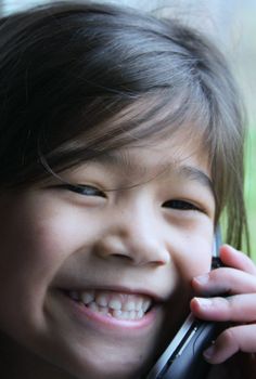 Six year old girl talking on cell phone.;