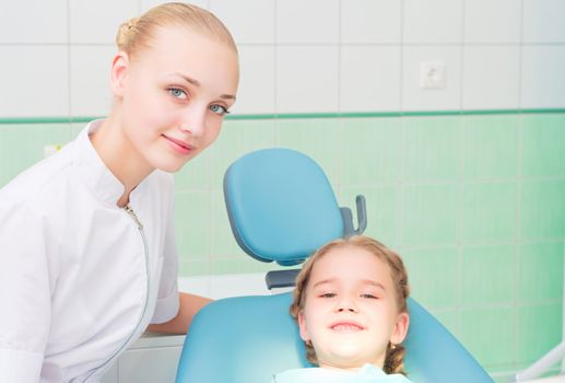 young doctor woman and girl in dentist office