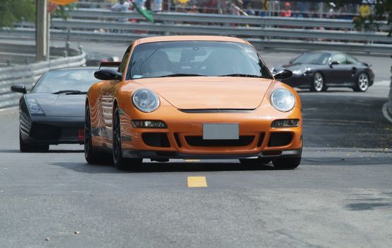 Orange, German sports car at a race track