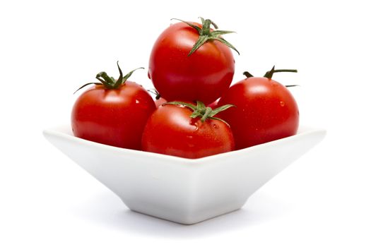 Cherry tomatoes in square bowl over white