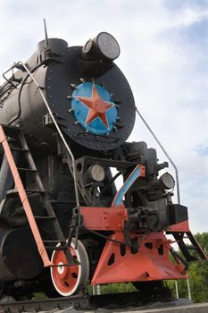 Old restored steam locomotive on a pedestal