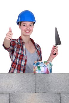 portrait of high-spirited female bricklayer thumb up