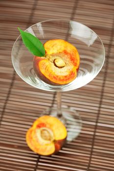 peach in the martini glass on a bamboo mat