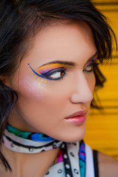 Portrait of beautiful young female with fancy colourful makeup