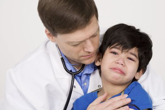 Male doctor comforting scared  toddler patient. Child is disabled with cerebral palsy.