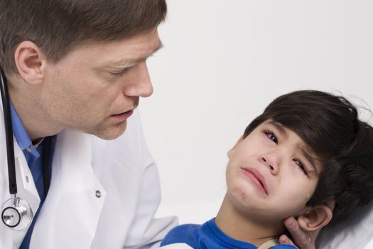 Male doctor comforting disabled  toddler patient. Child is five years old