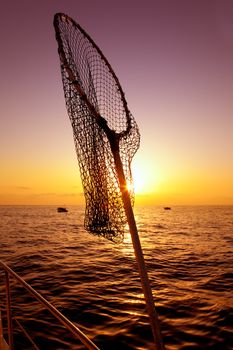 dip net in boat fishing on sunrise saltwater