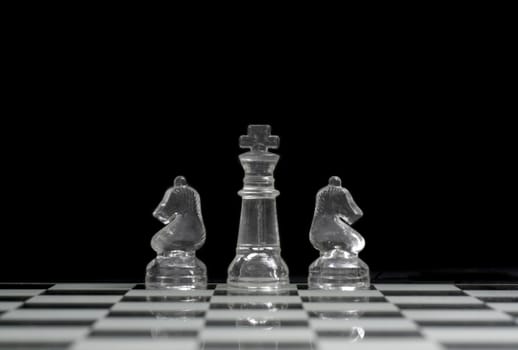 King and two Knights on the chess board with a black background