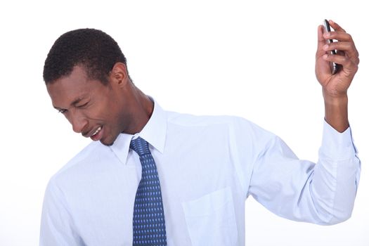 excited black man wincing and holding a cell phone in his hand