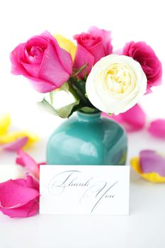 bouquet of colorful roses in vase,petals and card with the words