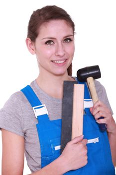 Female labourer holding mallet and sand paper