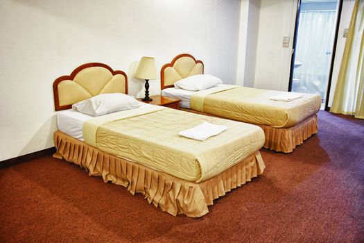 Two beds in the interior of an inexpensive hotel
