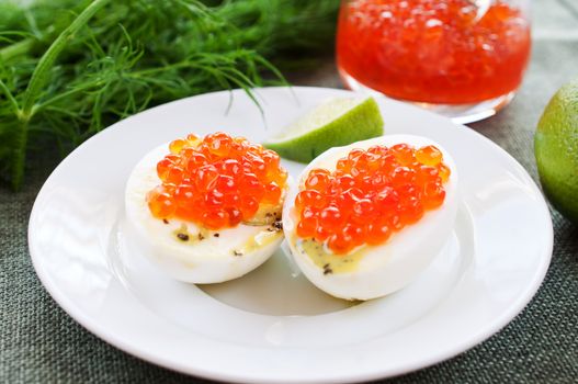 Eggs and caviar on white saucer