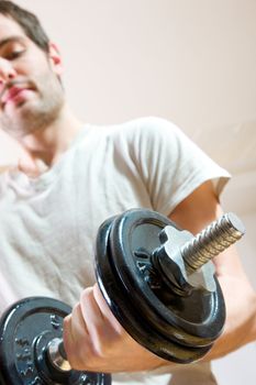 man lifting dumbbell in gym