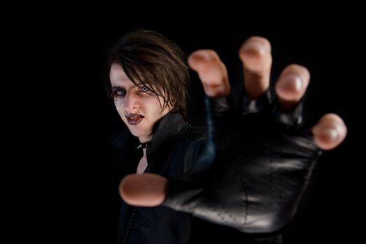 Gothic boy with artistic make-up stretching his hand 