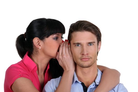 a woman whispering a secret to a man