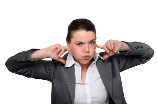 Brunette office worker with fingers in ears
