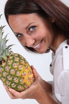 beautiful lady all smiles holding pineapple