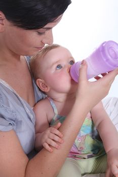 Girl giving baby her bottle
