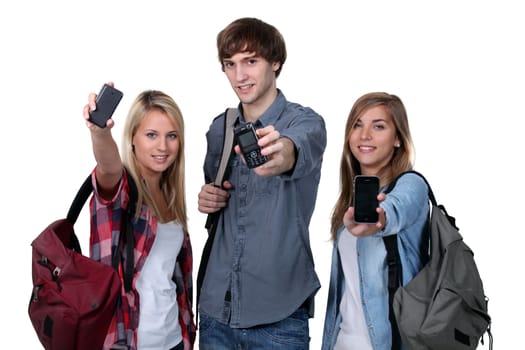 Three teenage students with backpacks and cellphones
