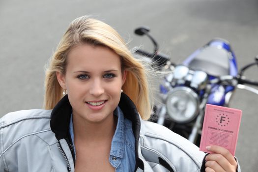 Teenage girl with motorbike and driving licence