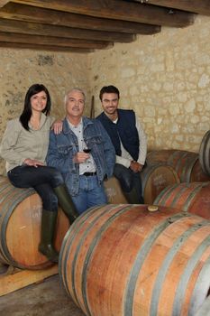 Three wine producers smiling in cellar