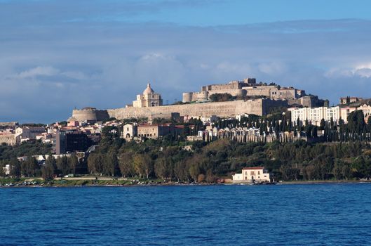 View from sea of Milazzo town in Sicily, Italy, with medieval castle on hilltop