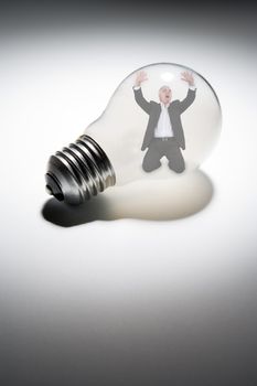 Senior businessman trapped in light-bulb