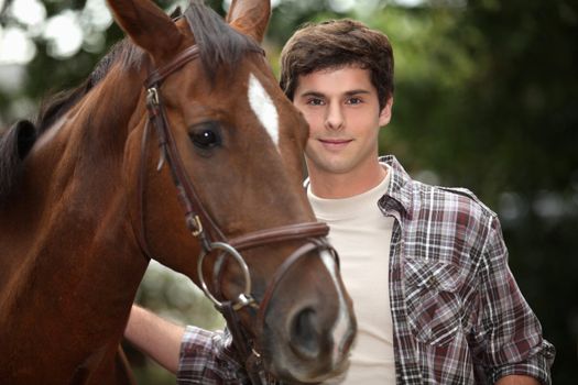 young man and a horse in the forest