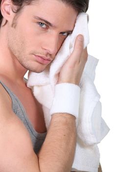 Man wiping his face with a bath towel