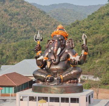 Giant Hindu God Ganesh on top of the building in a temple in Tha