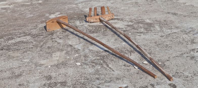 Wooden shovel and rake on the ground