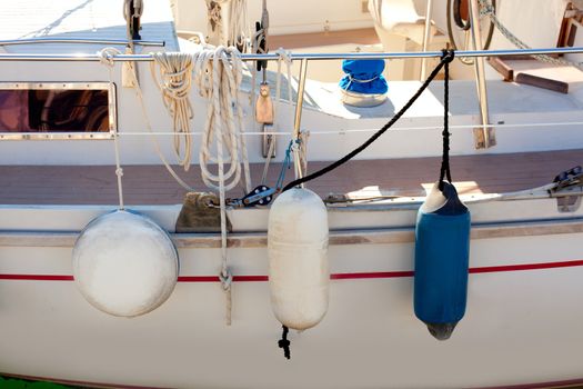 fender buoys on sailboat side with ropes