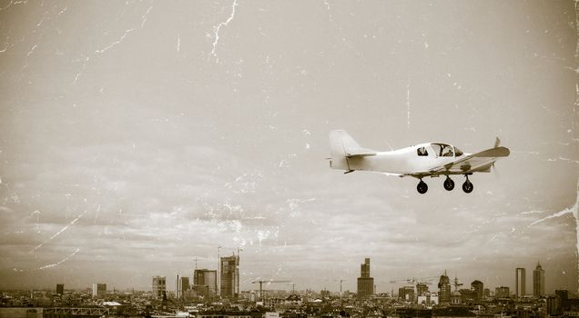 Vintage image of a personal plane flying over the city
