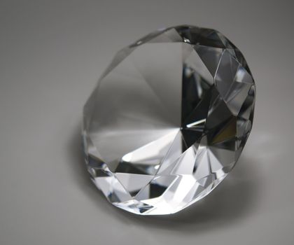 studio photography of a clear diamond in grey back