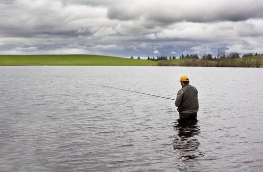 Angler fishing in a small lake in Scotland