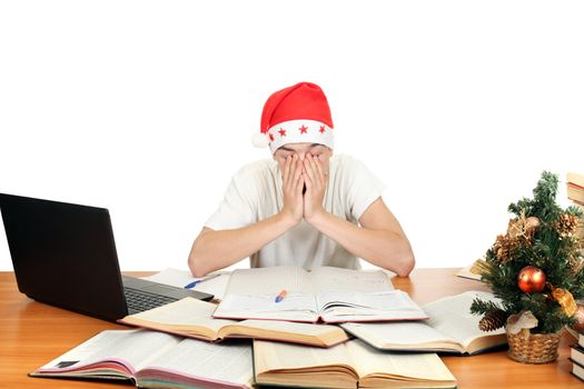 tired and sleepy student in santa's hat after hard work for exam. isolated on the white background