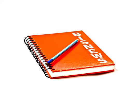 Red book with blue pencil on white background.