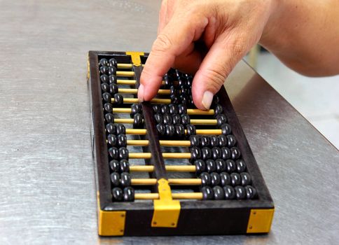 Abacus with old man's hand 