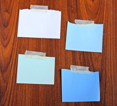 Notepaper attach with tape on wooden background