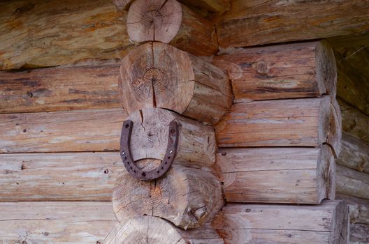 Horseshoe hang on log house corner. Luch symbol