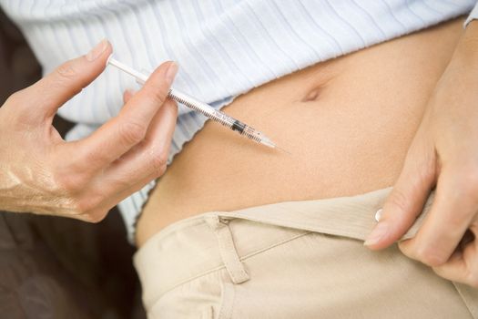 Woman injecting drugs to prepare for IVF treatment